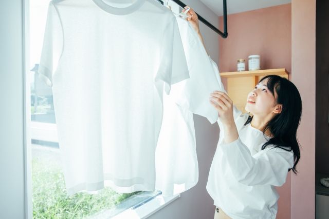 一人暮らしで洗濯物を部屋干しする女性