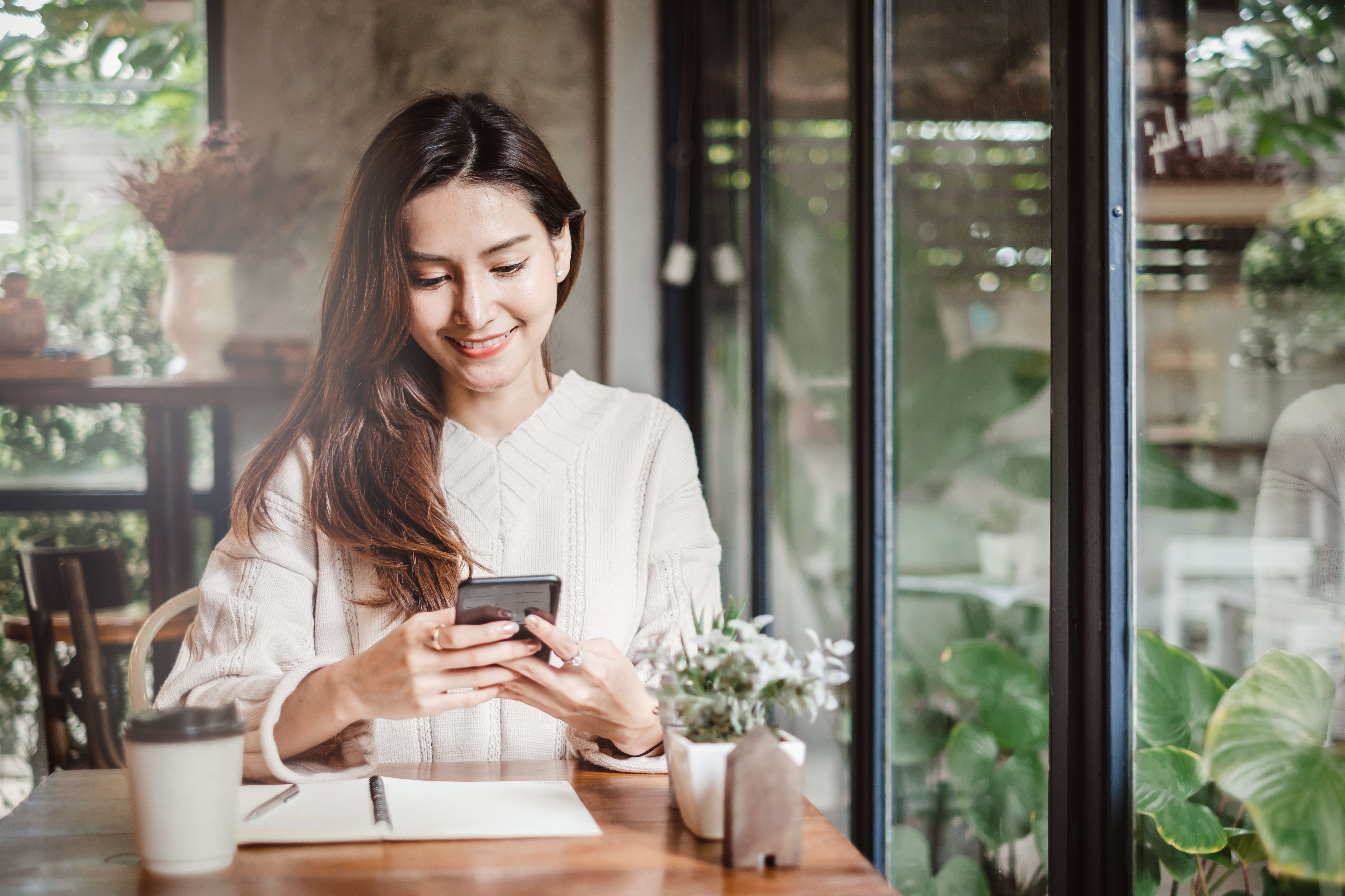 ベッドのサイズ表を見て、ベッドを交換するためにスマホで連絡する人