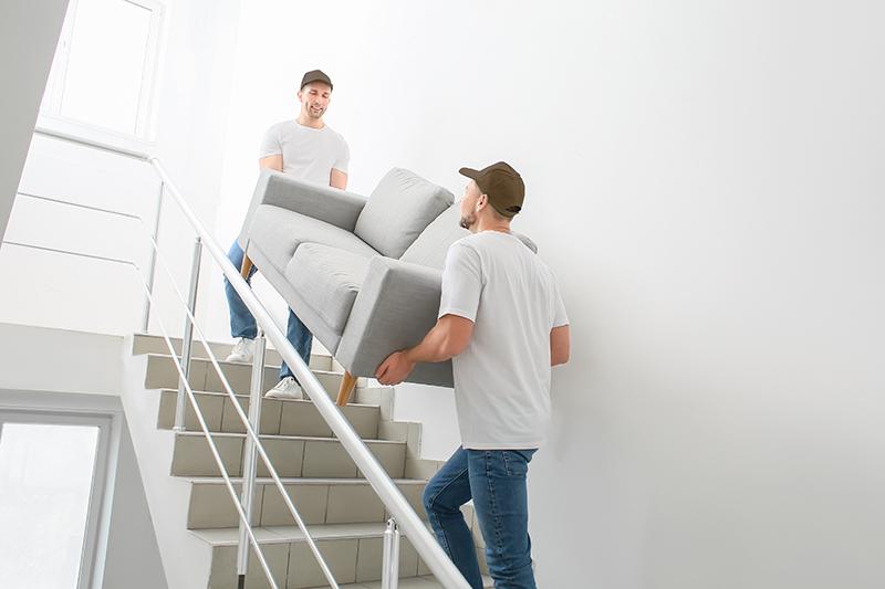 大型家具ソファを二人で運ぶ様子