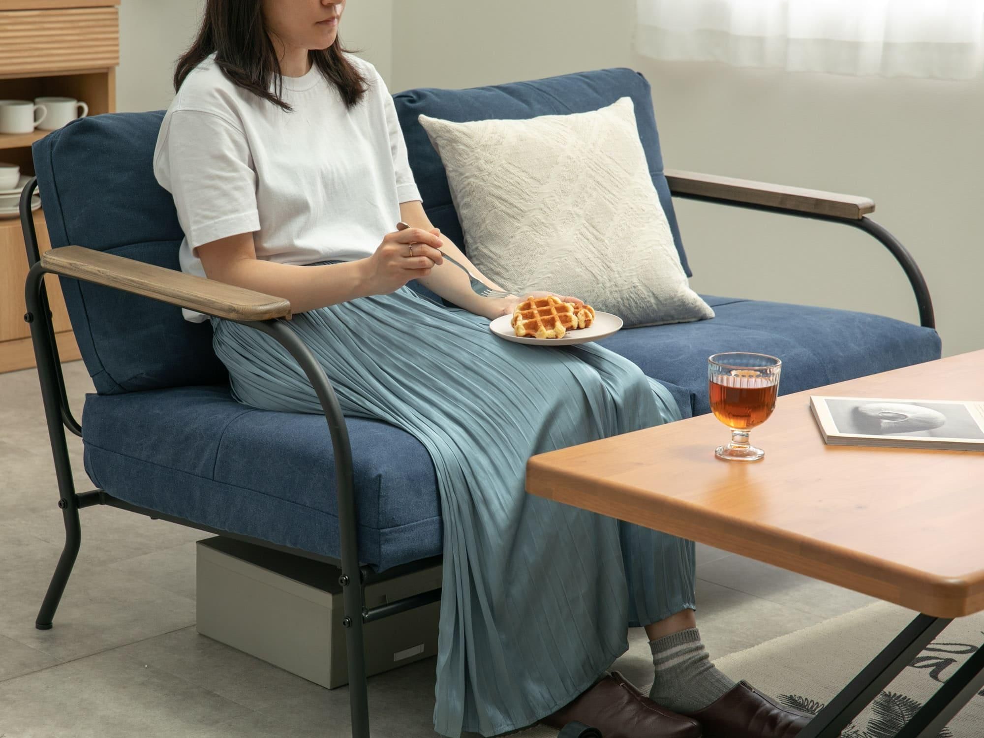 ソファとテーブルで食事する一人暮らし