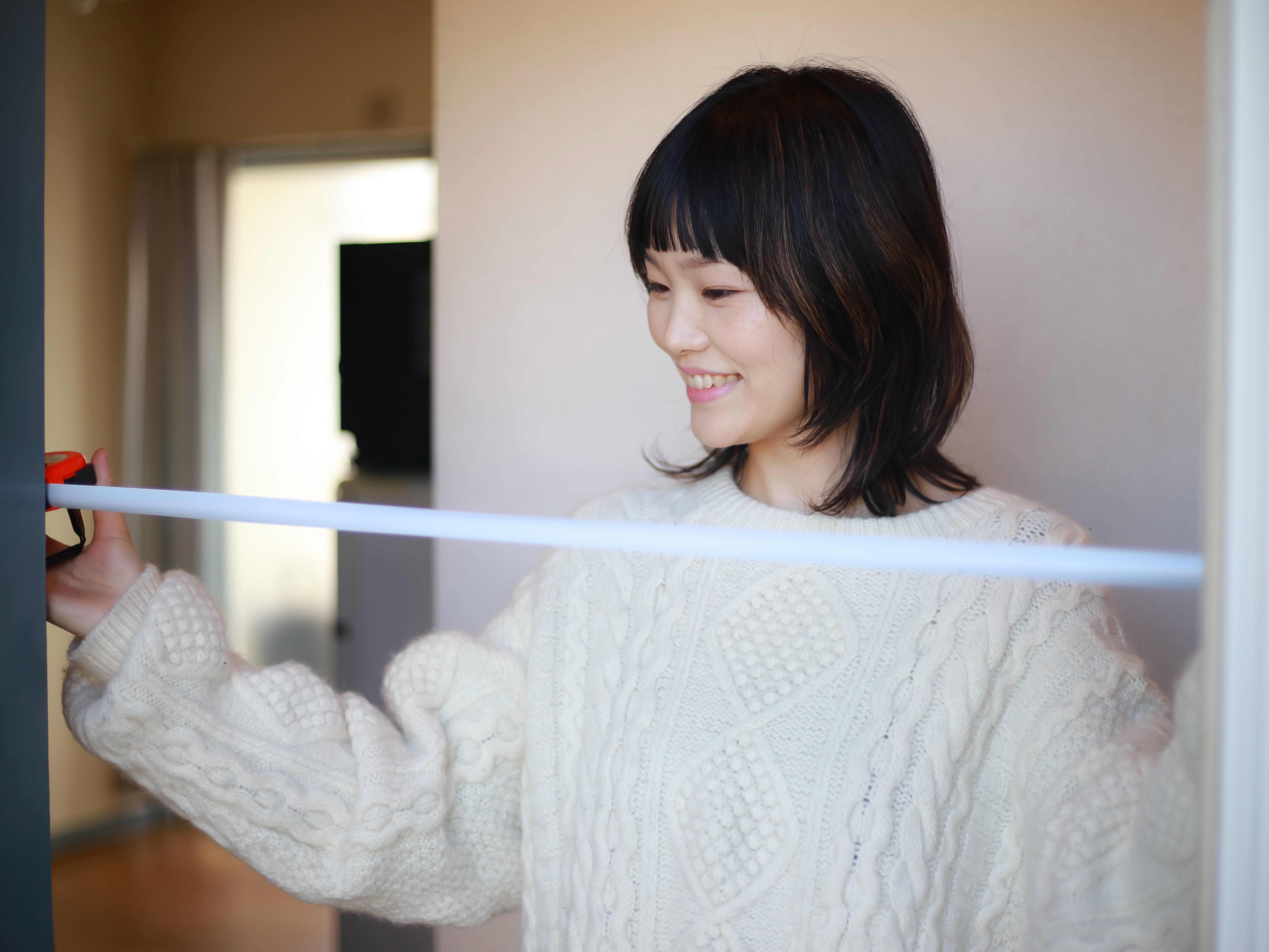冷蔵庫の幅を測る女性