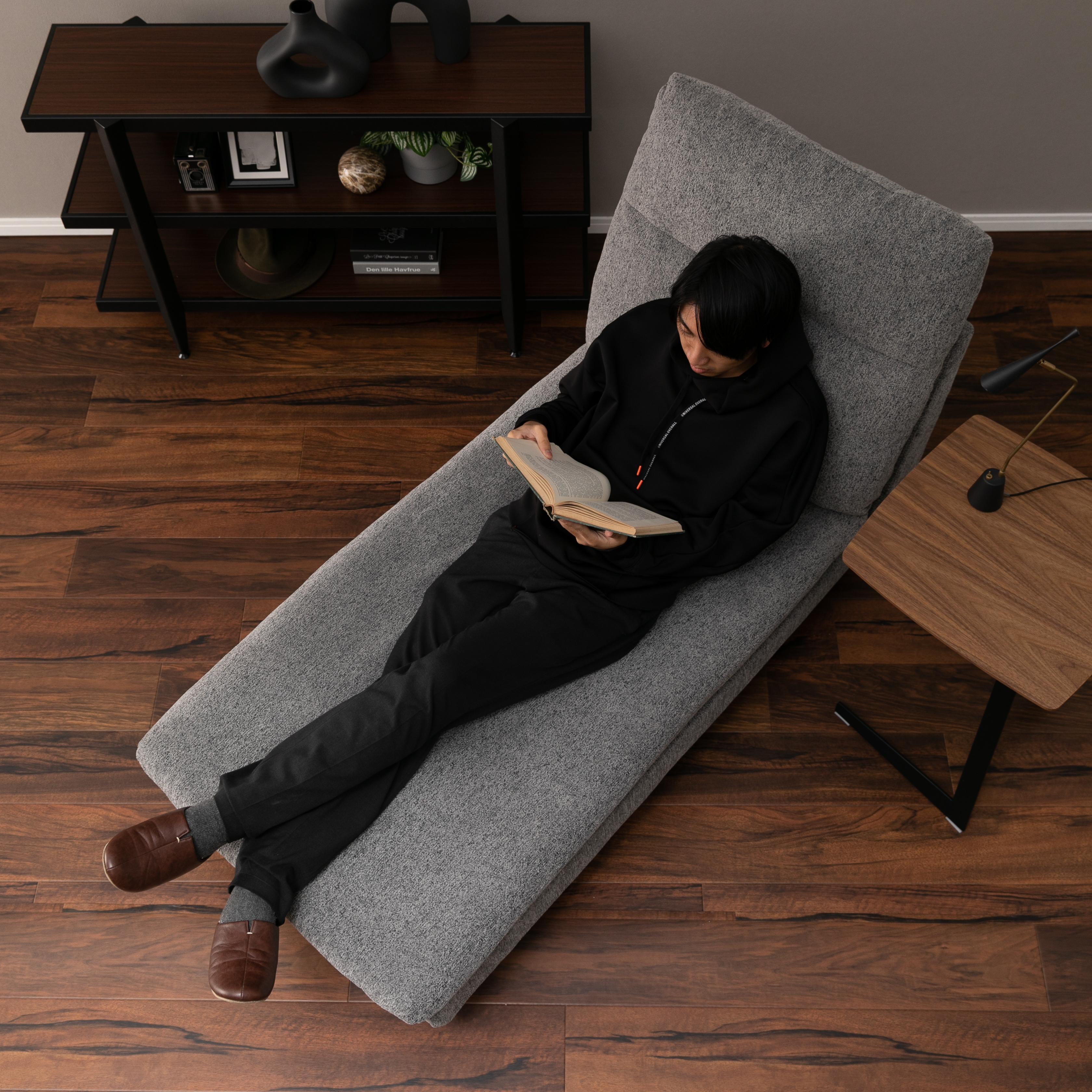 理想のハイバックソファを手に入れて、くつろいでいる男性