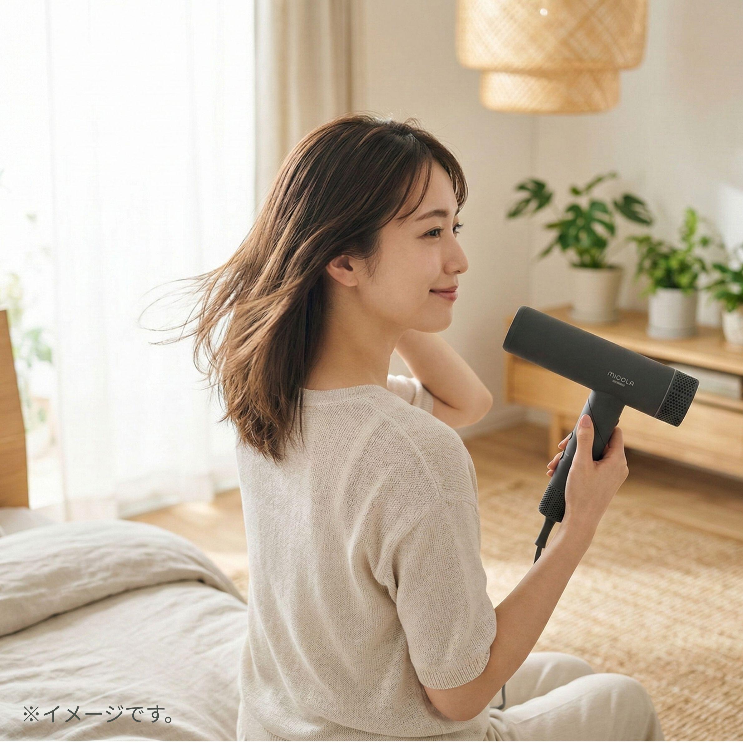 アイリスオーヤマのミコラ ドライヤーの大風量で髪を乾かす女性