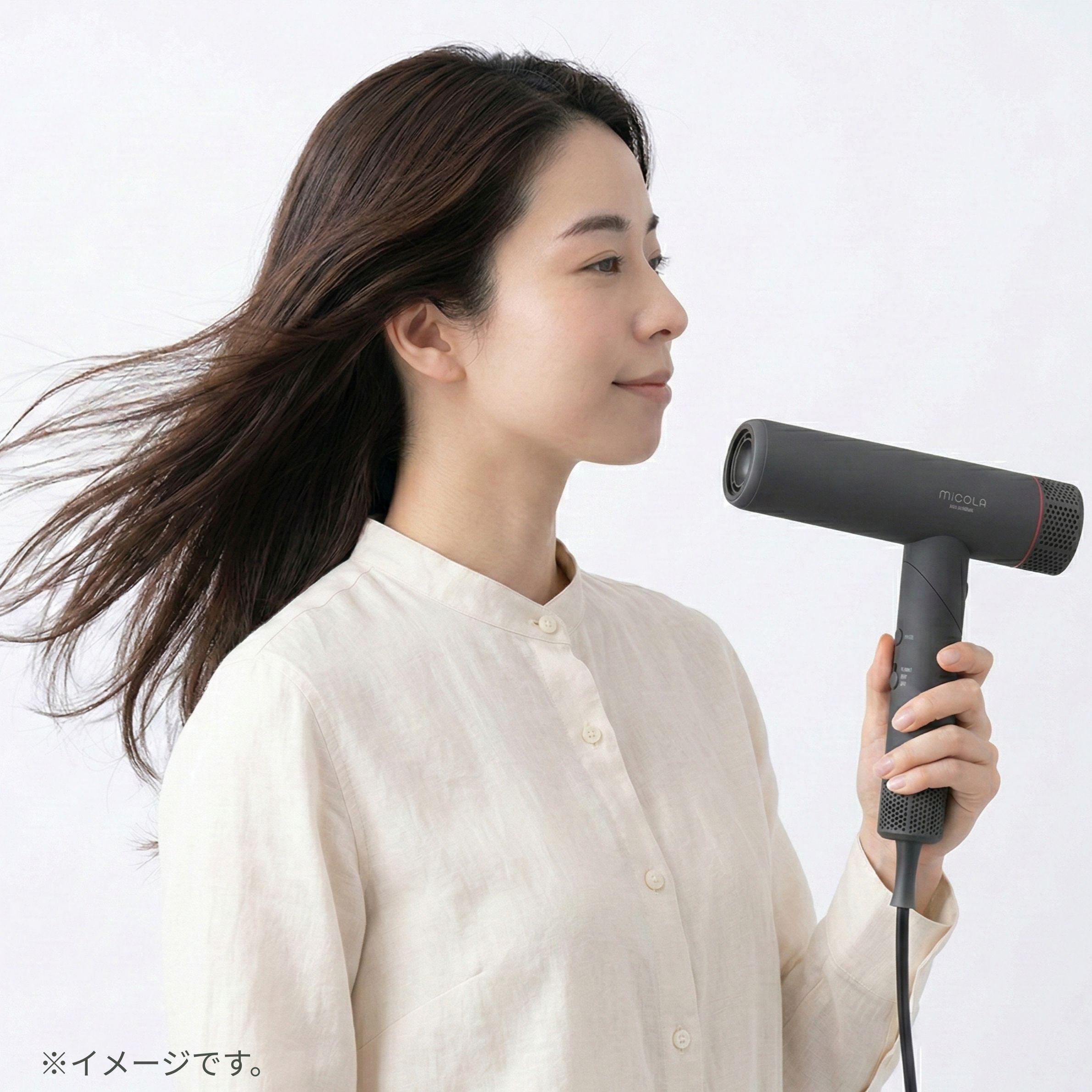アイリスオーヤマ ミコラ ドライヤーを離して髪を乾かす女性