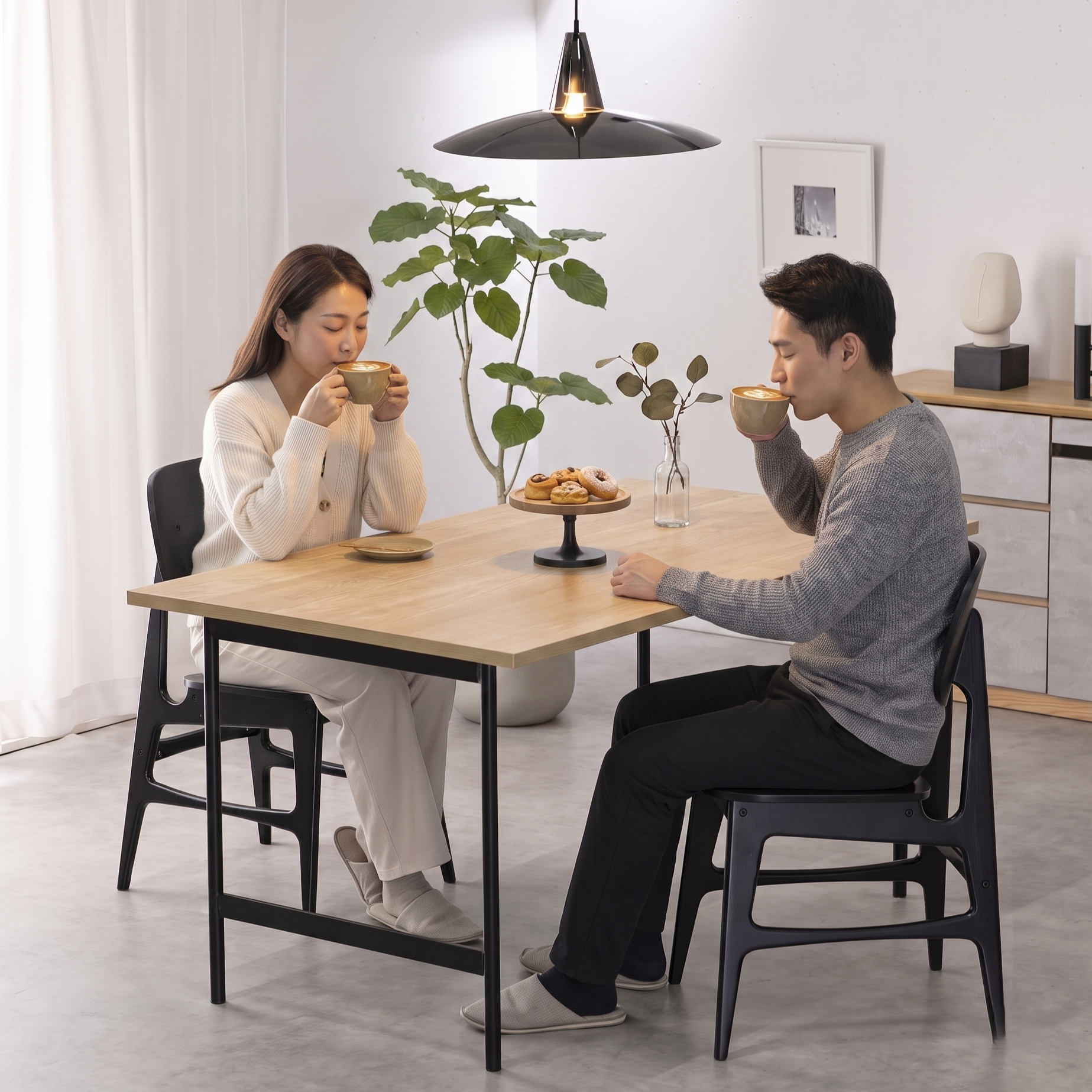 ダイニングでタイガーのコーヒーメーカーで入れたコーヒーを飲む若い夫婦