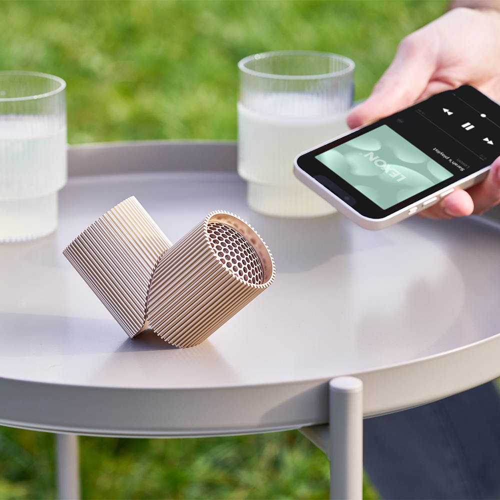 防水ワイヤレススピーカーで音楽再生する人の手
