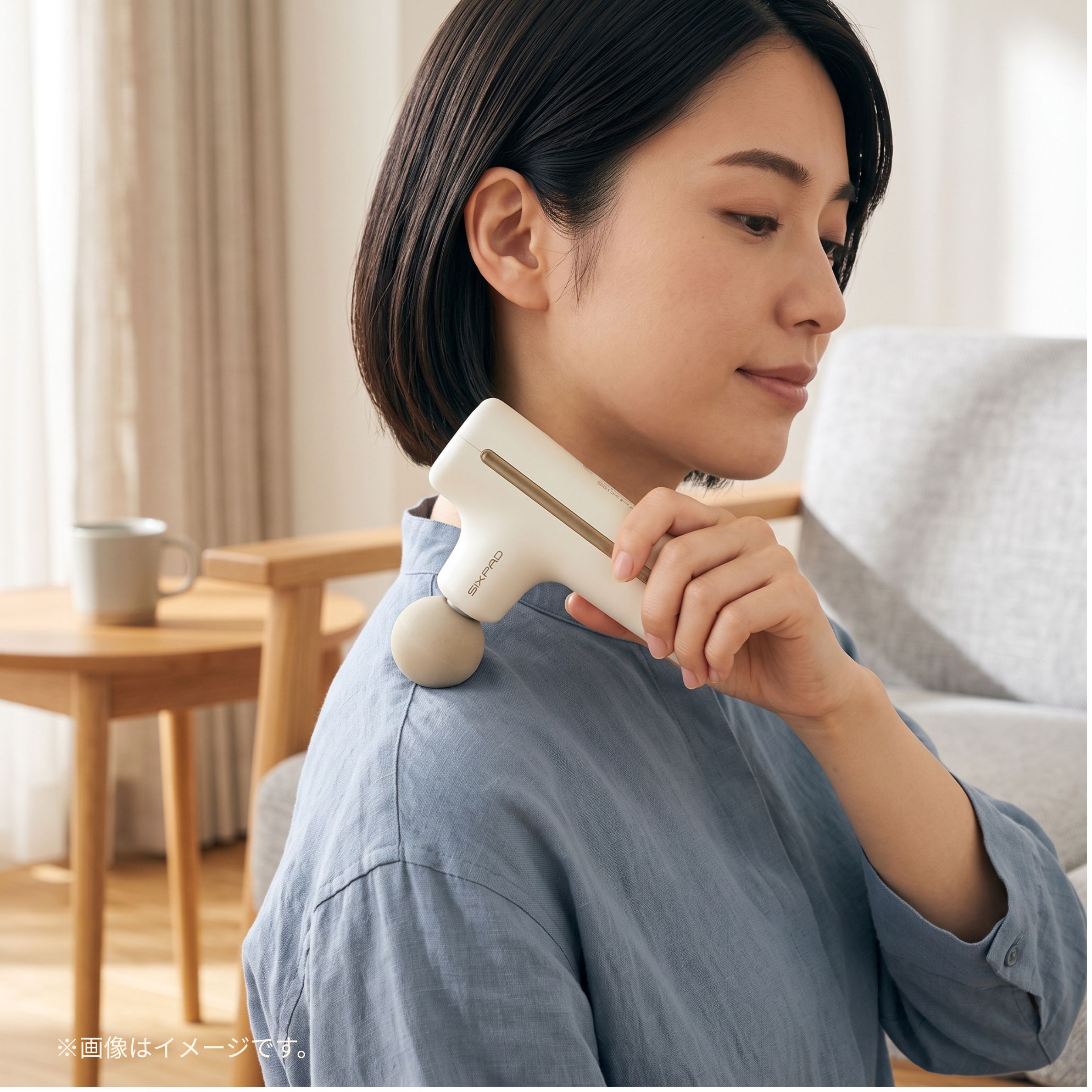 筋膜リリースガンを試す女性