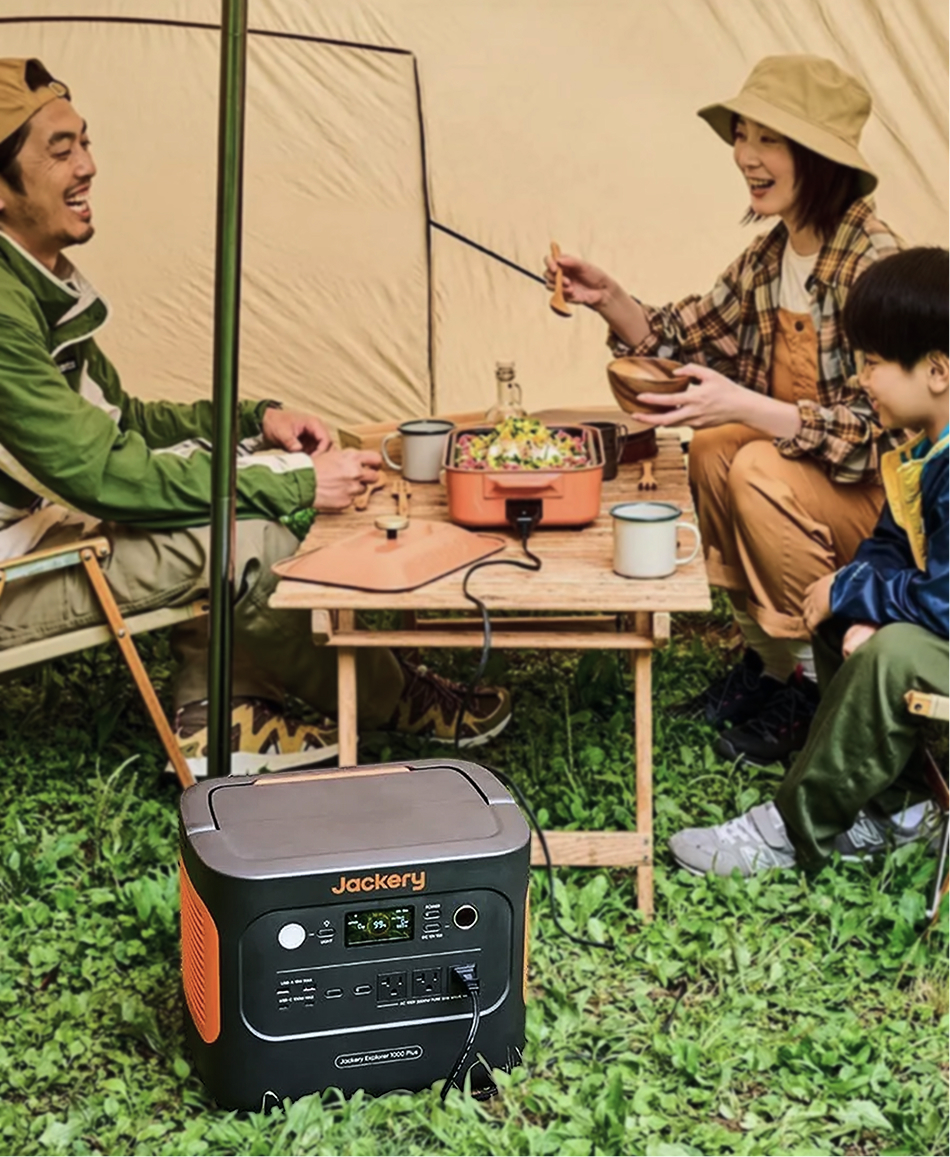 テントの前でポータブル電源を囲む家族