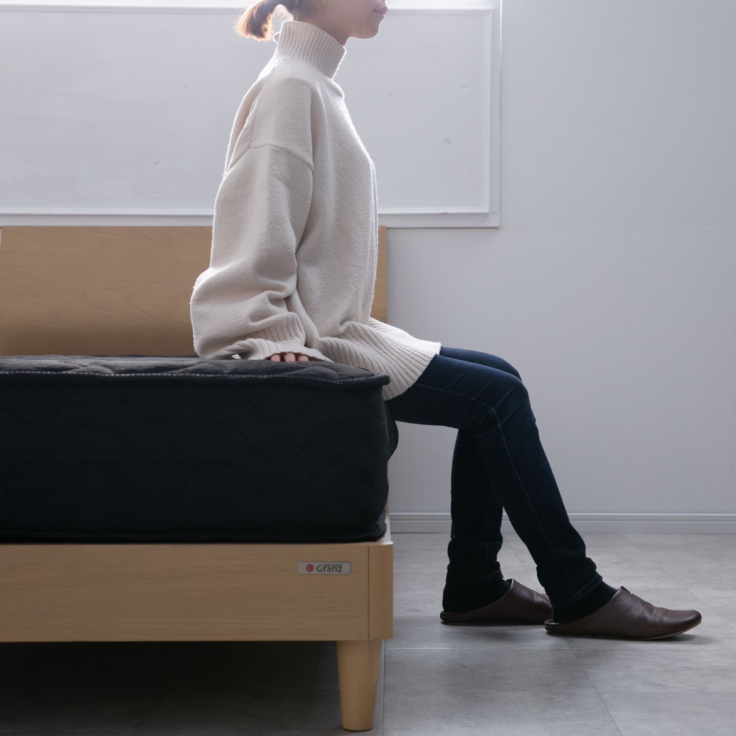 一人暮らしのベッドおすすめに座る女性